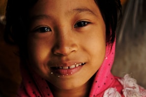 A toddler in a cozy pastel hoodie and soft pants, smiling happily.