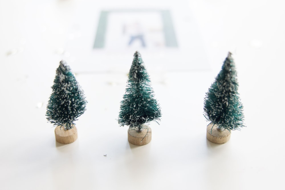 Three little pretend Christmas trees on a table.
