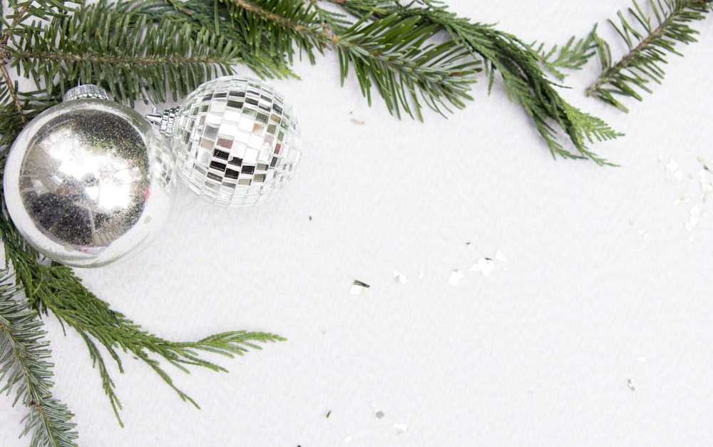 a silver ornament sitting on top of a christmas tree