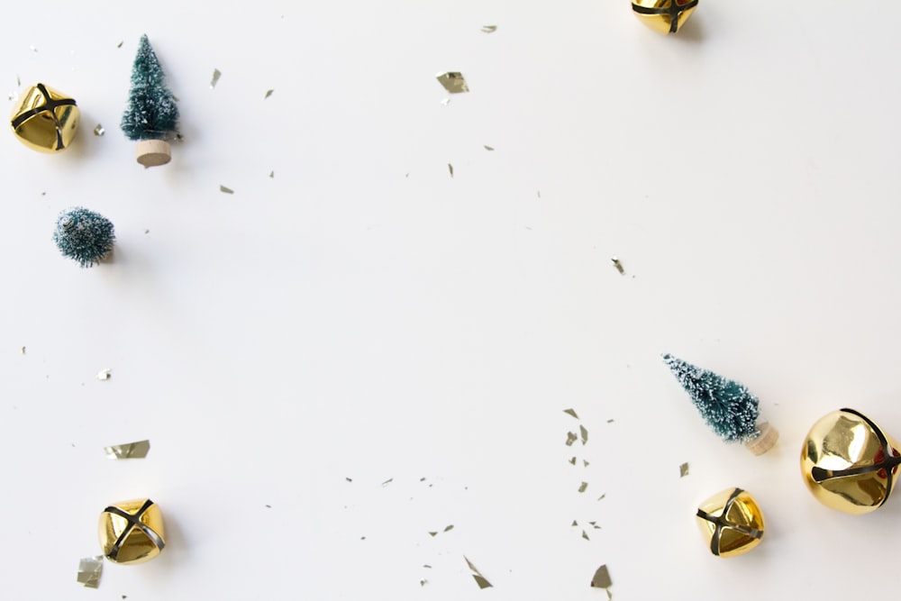 a white table topped with gold bells and christmas trees