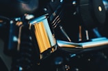 Close-up of a shiny motorcycle engine part on a workbench with tools around