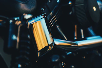 Close-up of a shiny motorcycle engine part with intricate details and a polished finish.