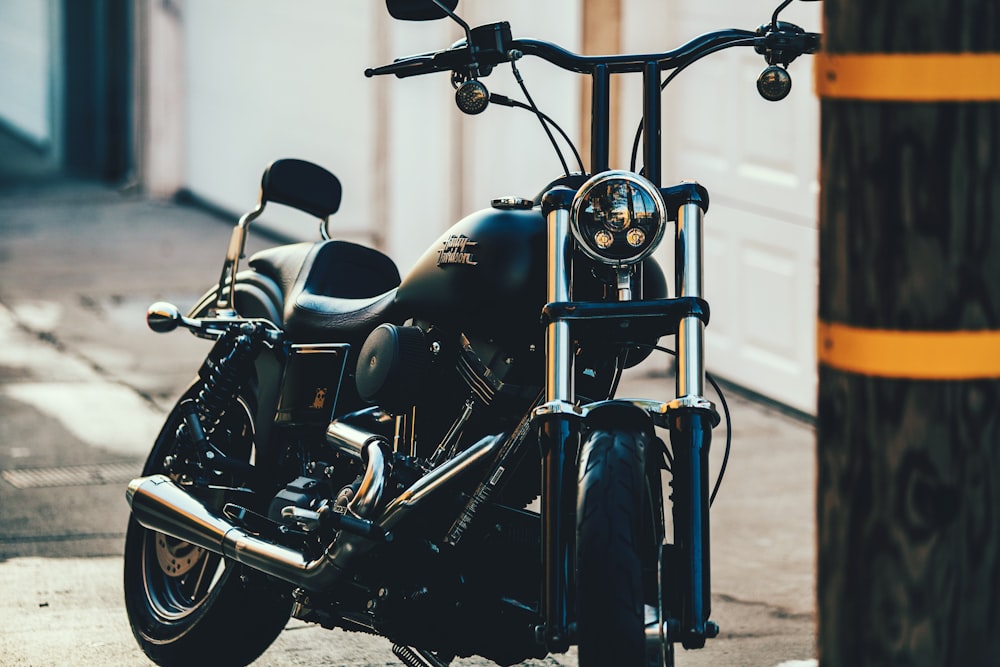 black cruiser motorcycle near black street post