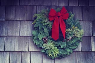 green and red Christmas wreath mounted on wall