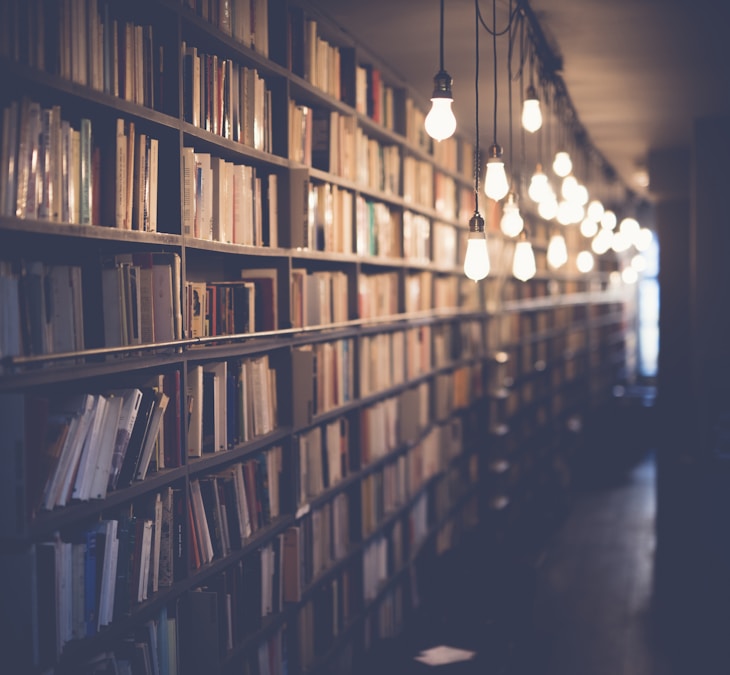 Offene Bücher und Notizbuch in einer Bibliothek
