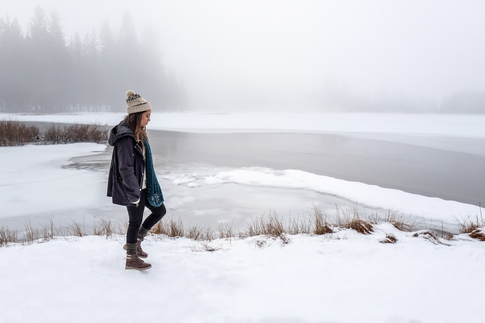 woman wearing black jacket walking on snow