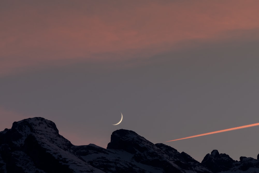 photo of black boulder and crescent moon