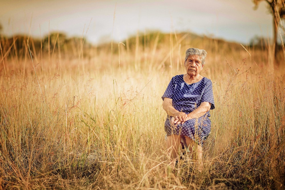 Frau sitzt auf Stuhl und ist von Gras umgeben