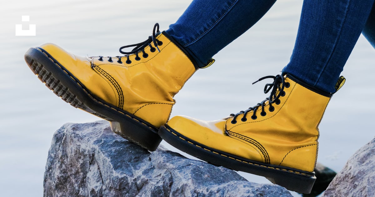 Personne portant des bottes Doc Martens Airwair jaunes sur roche
