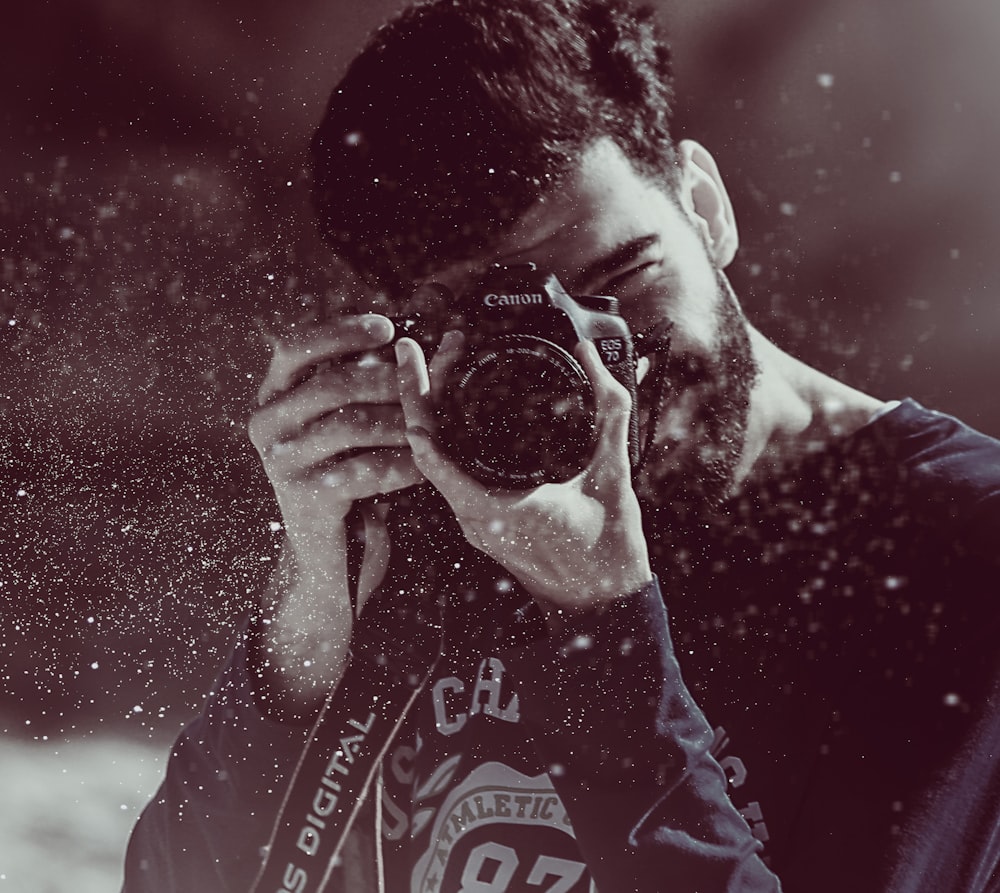캐논 카메라를 사용하여 사진을 찍는 사람의 사진