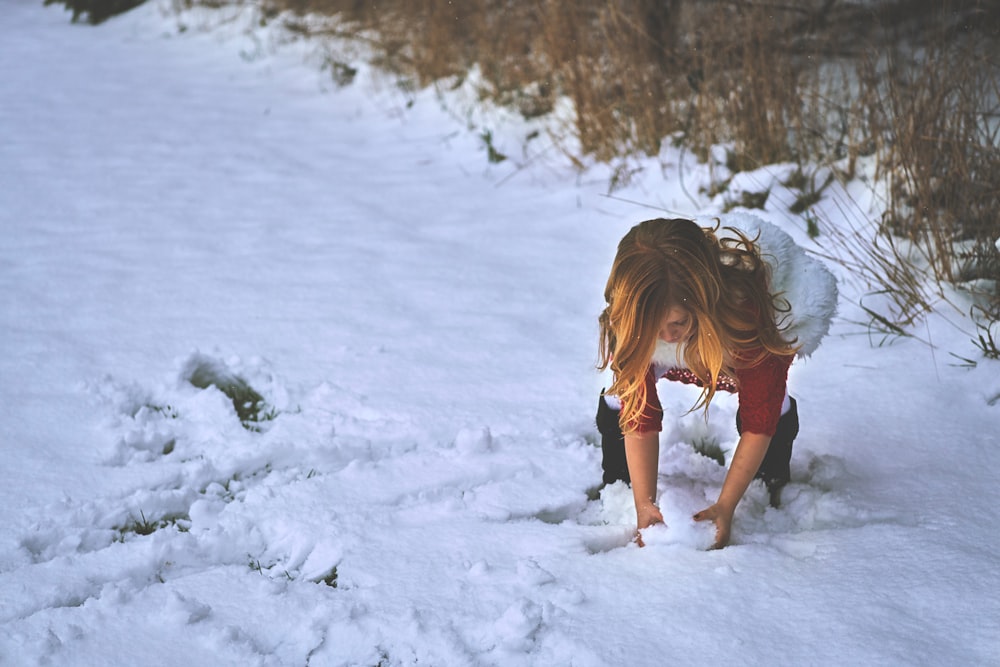 Female child grabbing snow in her hands to play at DuPage River Park