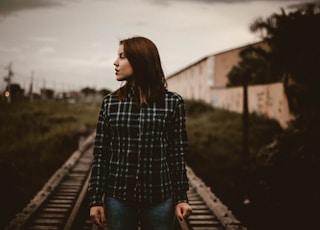 woman standing on train rail track