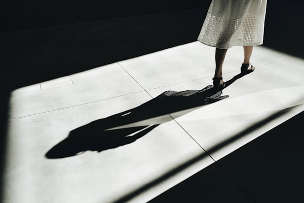 Elongated shadow of woman walking.