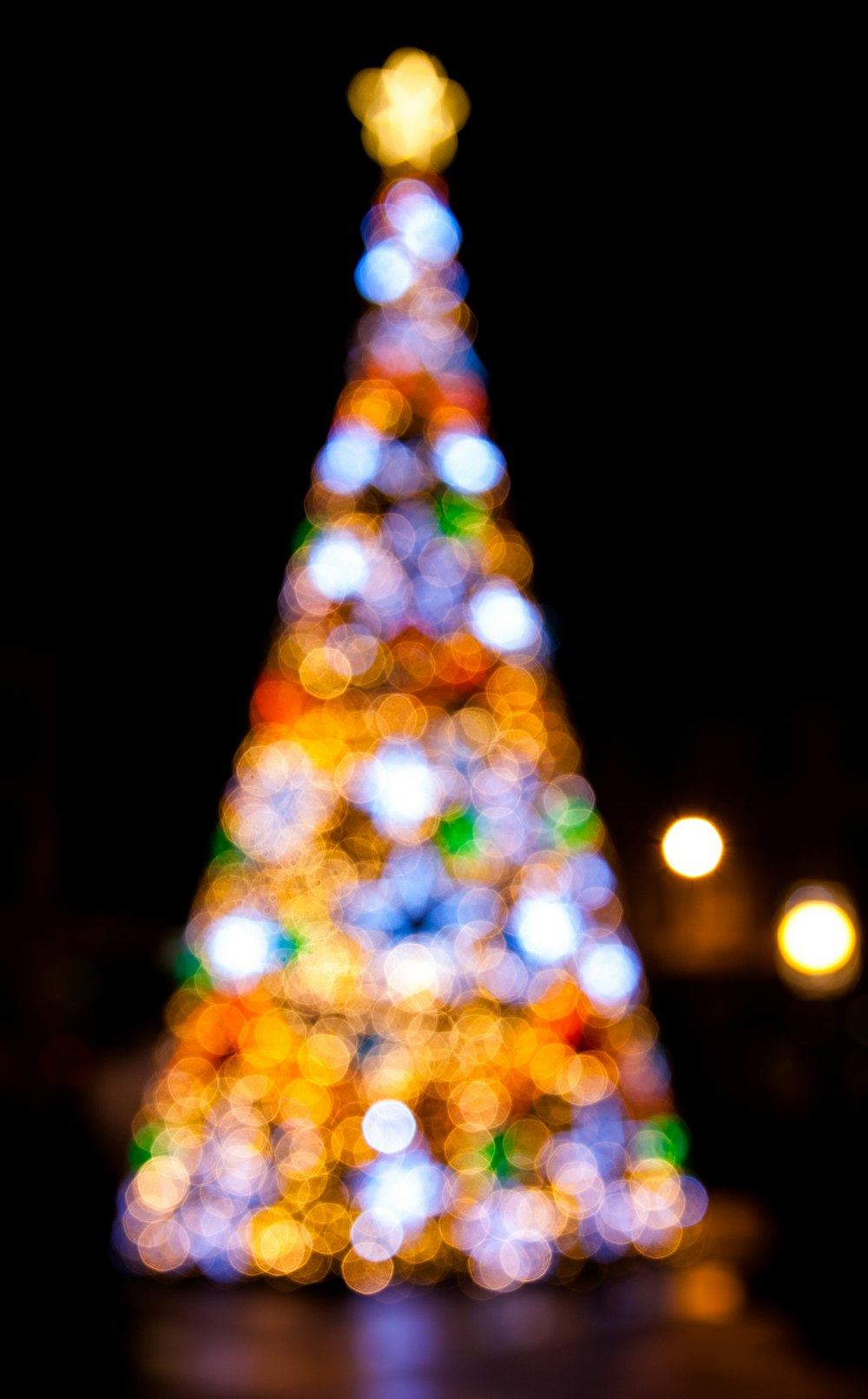 a brightly lit christmas tree in the dark