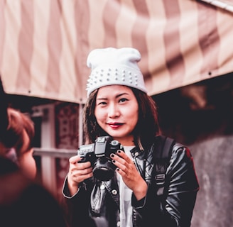 woman in black leather jacket holding DSLR camera