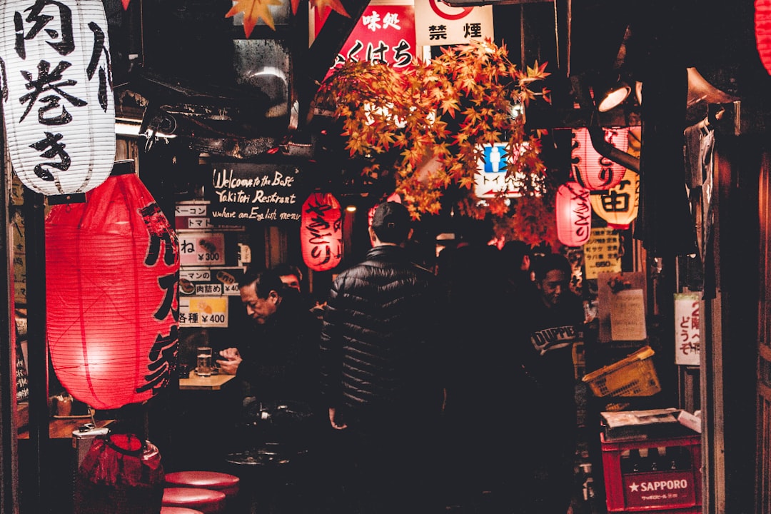 person standing in between buildings at night time, Narrow market alley