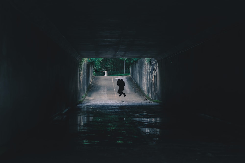 silhouette of person inside tunnel