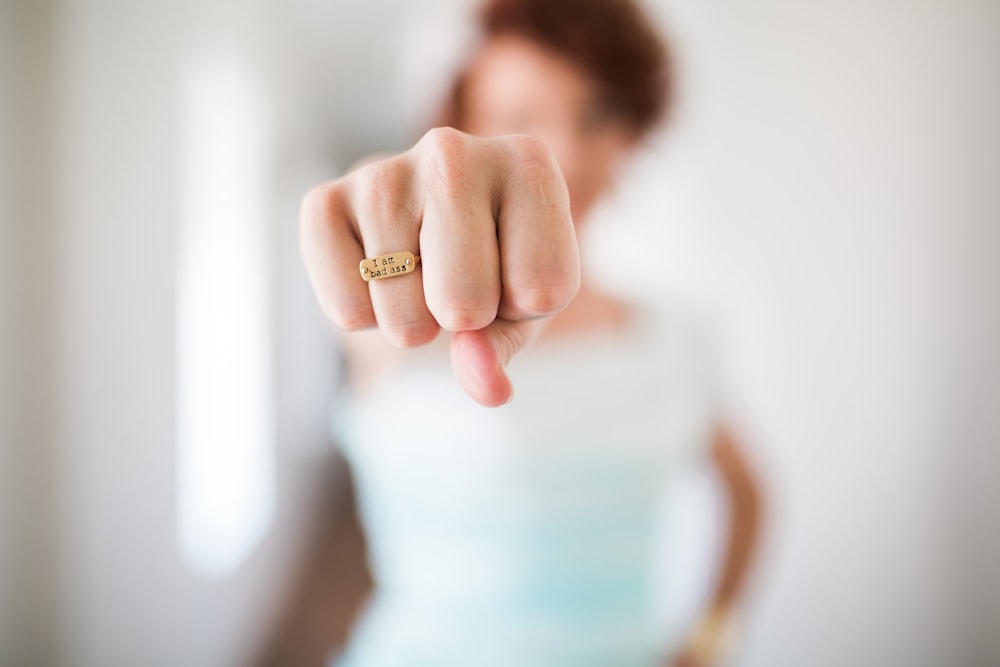 A person's clenched fist with an engraved ring with the phrase "I am badass"