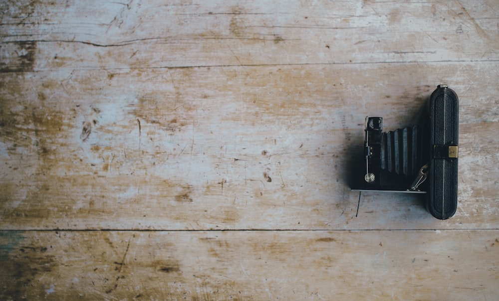 classic black camera on brown wooden surface