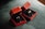 Two red velvet boxes are open to display elegant gold rings with intricate designs. The boxes are placed on a textured dark green fabric, creating a luxurious setting.