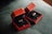 Two red velvet boxes are open to display elegant gold rings with intricate designs. The boxes are placed on a textured dark green fabric, creating a luxurious setting.