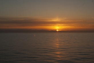 A vibrant sunrise over a calm ocean, symbolizing new beginnings and warmth.