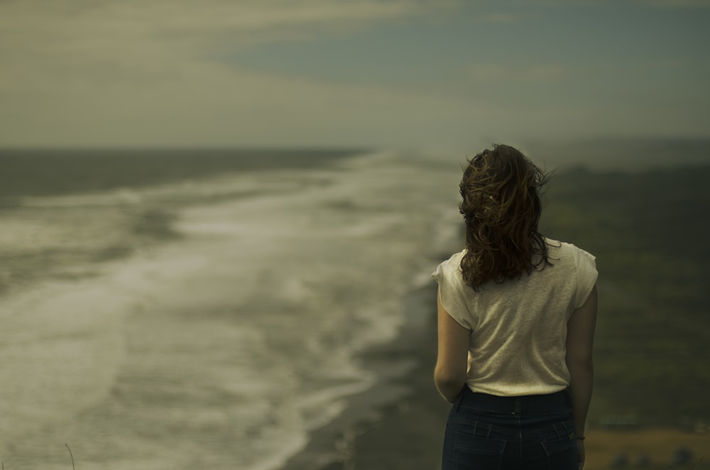donna in piedi vicino alla riva del mare