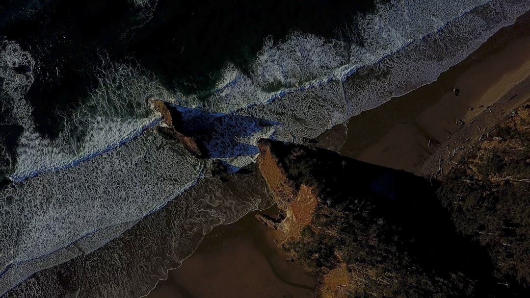 aerial photography of water waves and rock formation during daytime