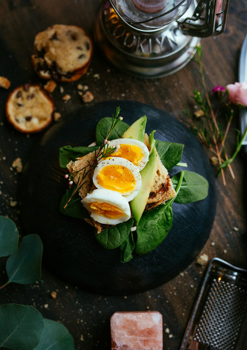 Avocado toast with egg and herbs on a rustic table