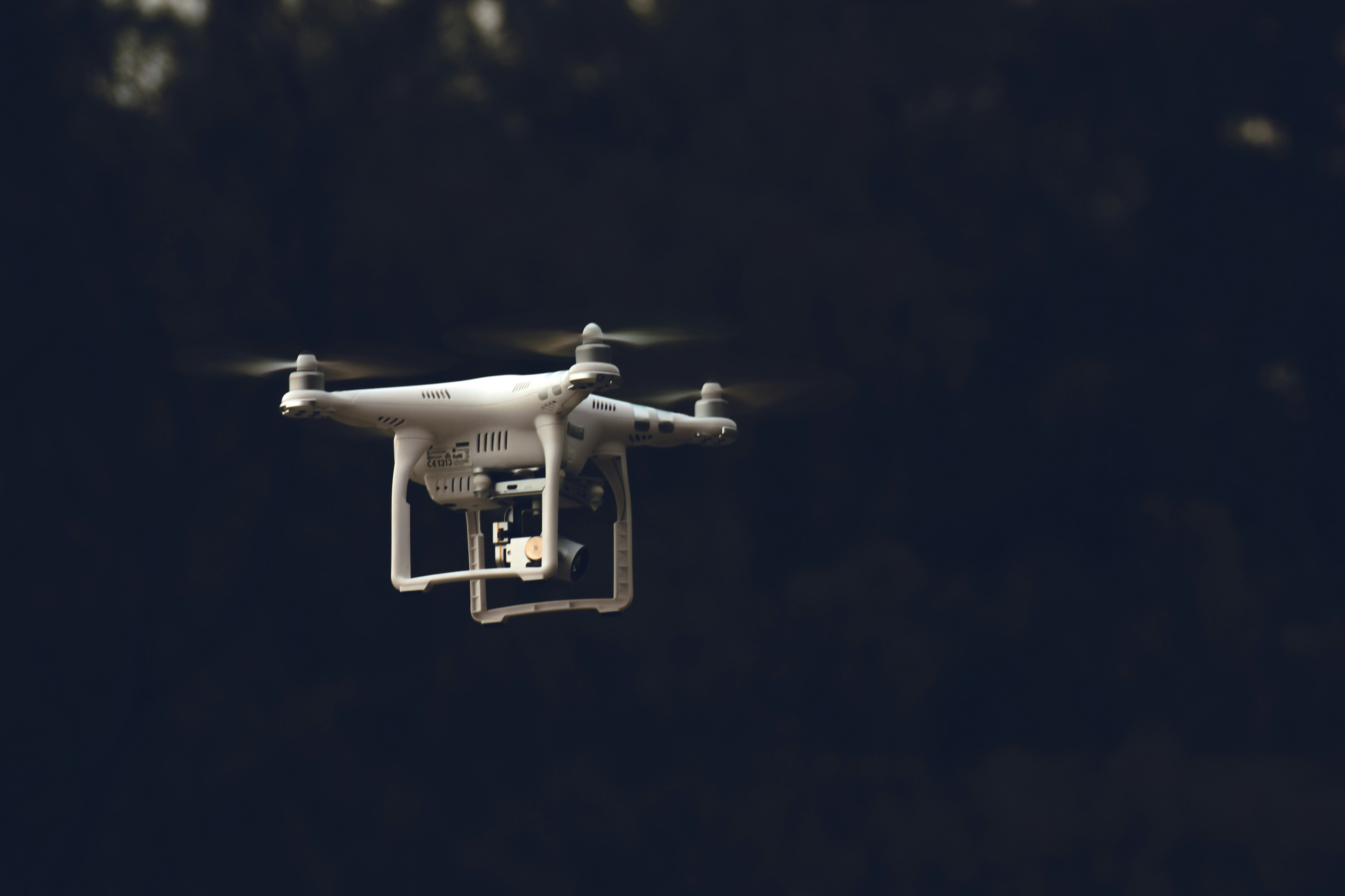 white DJI phantom-series quadcopter flying during daytime