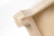 A close-up view of a wooden corner joint, displaying the intricate pattern of layered wood grain and precise craftsmanship. The natural wood color gives it a simple yet elegant appearance.