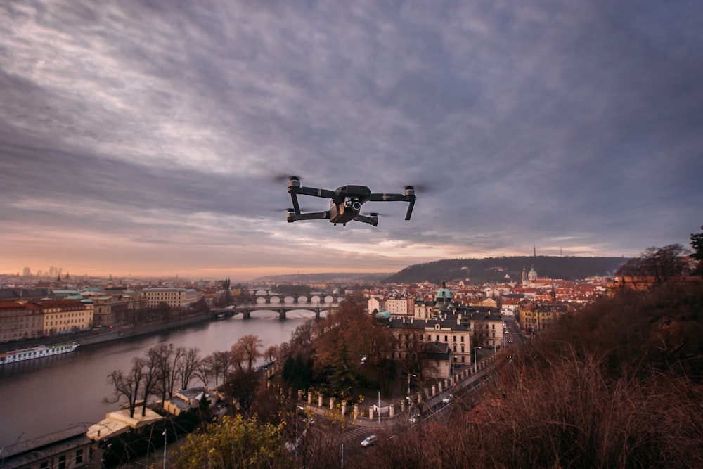 black quadcopter drone flying over the hill during daytime