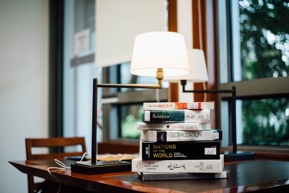 Pile de livres à côté de la lampe de table