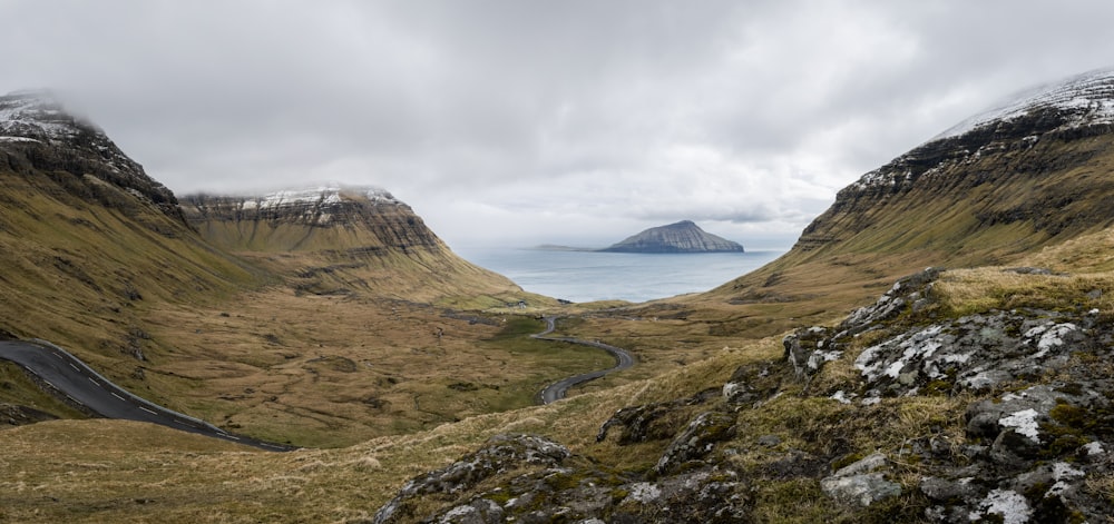 Brauner und grauer Berg in der Nähe des Gewässers während des Tages