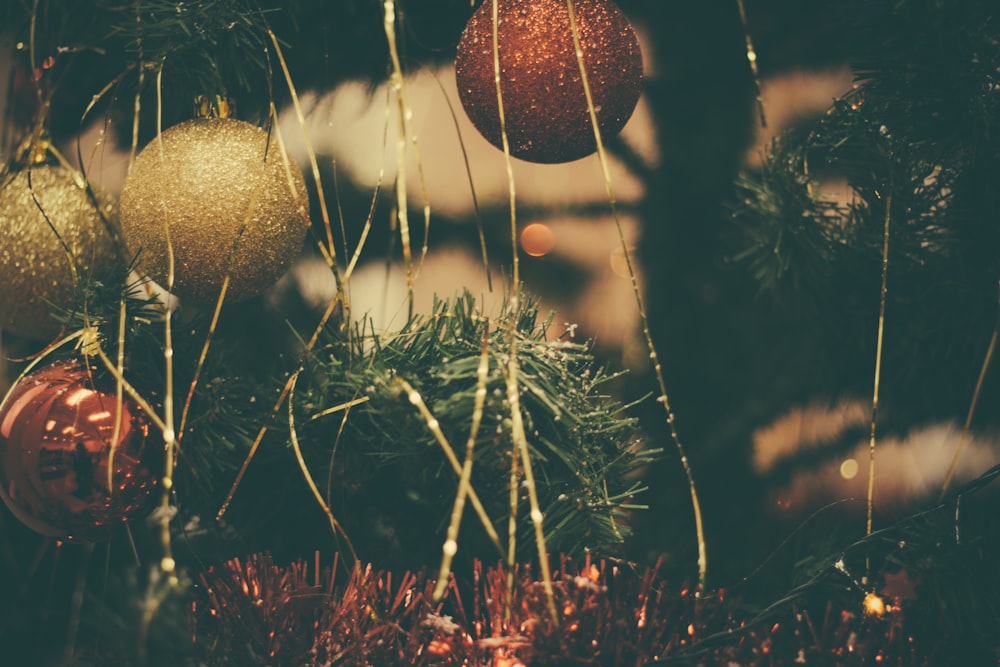 gold christmas baubles on green christmas tree