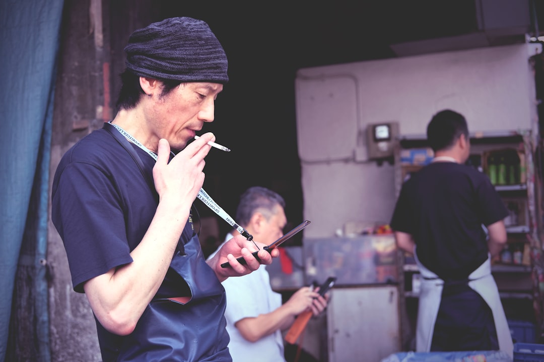 man smoking outside the house, Man in apron smokes cigarette