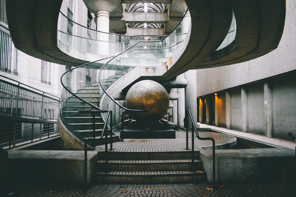 landscape photography of grey staircase with globe under