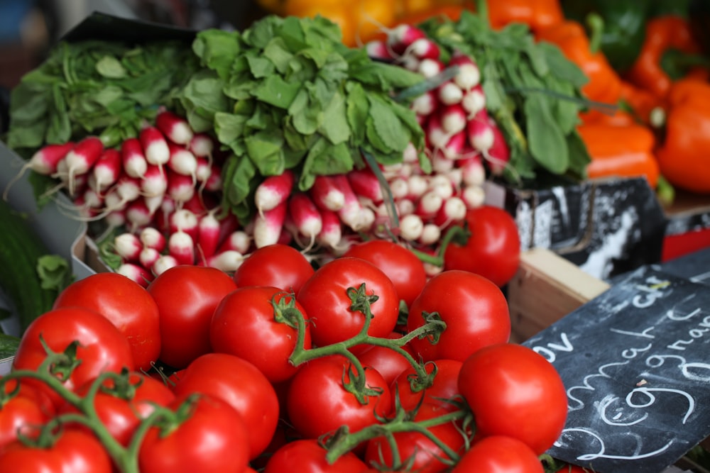 bunch of red tomatoes on top of black surface