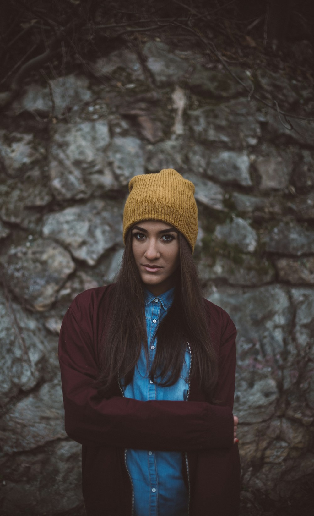 woman wearing brown knit cap standing in front of gray wall