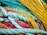 A collection of vibrant ropes and nets intertwined, showcasing a variety of textures and patterns. The colors are vivid and the ropes appear thick and sturdy, indicating they might be used for maritime purposes.
