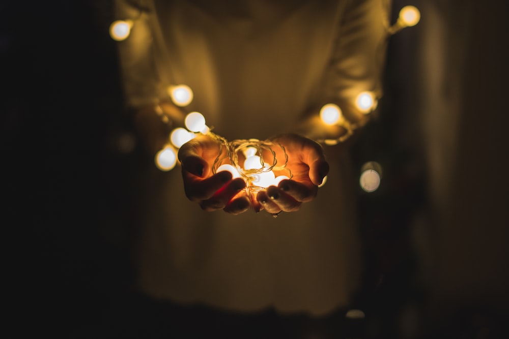 person holding string lights