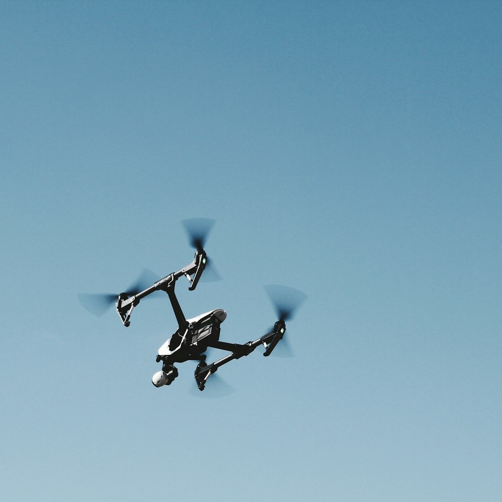 black and gray quadcopter drone in mid air
