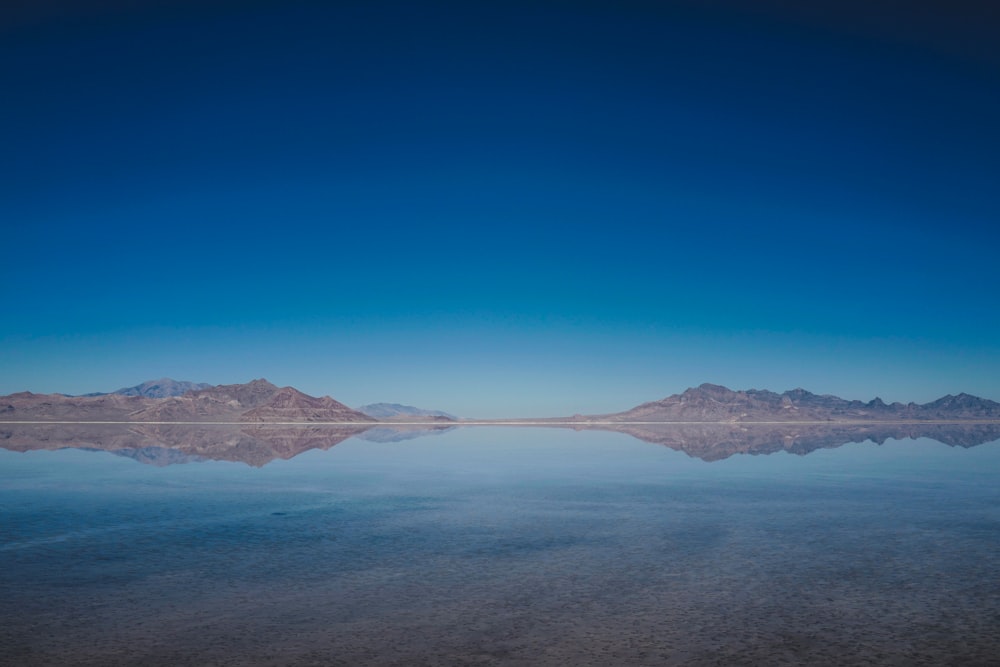 specchio d'acqua e montagne durante il giorno