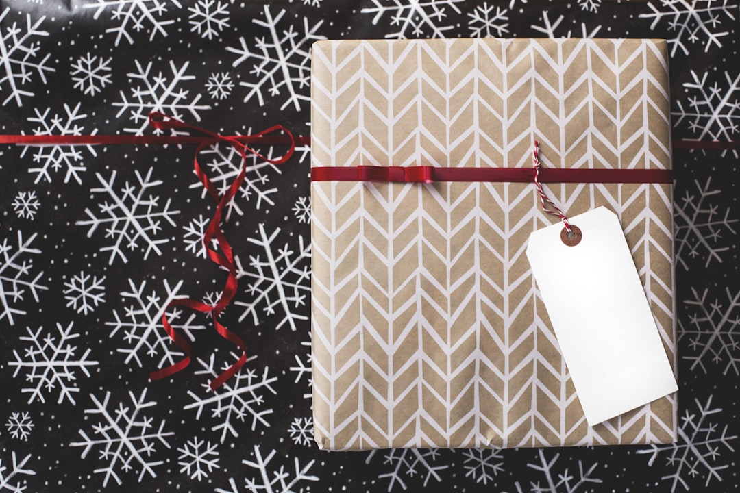 gold and white gift box on white and black fair-isle print surface,