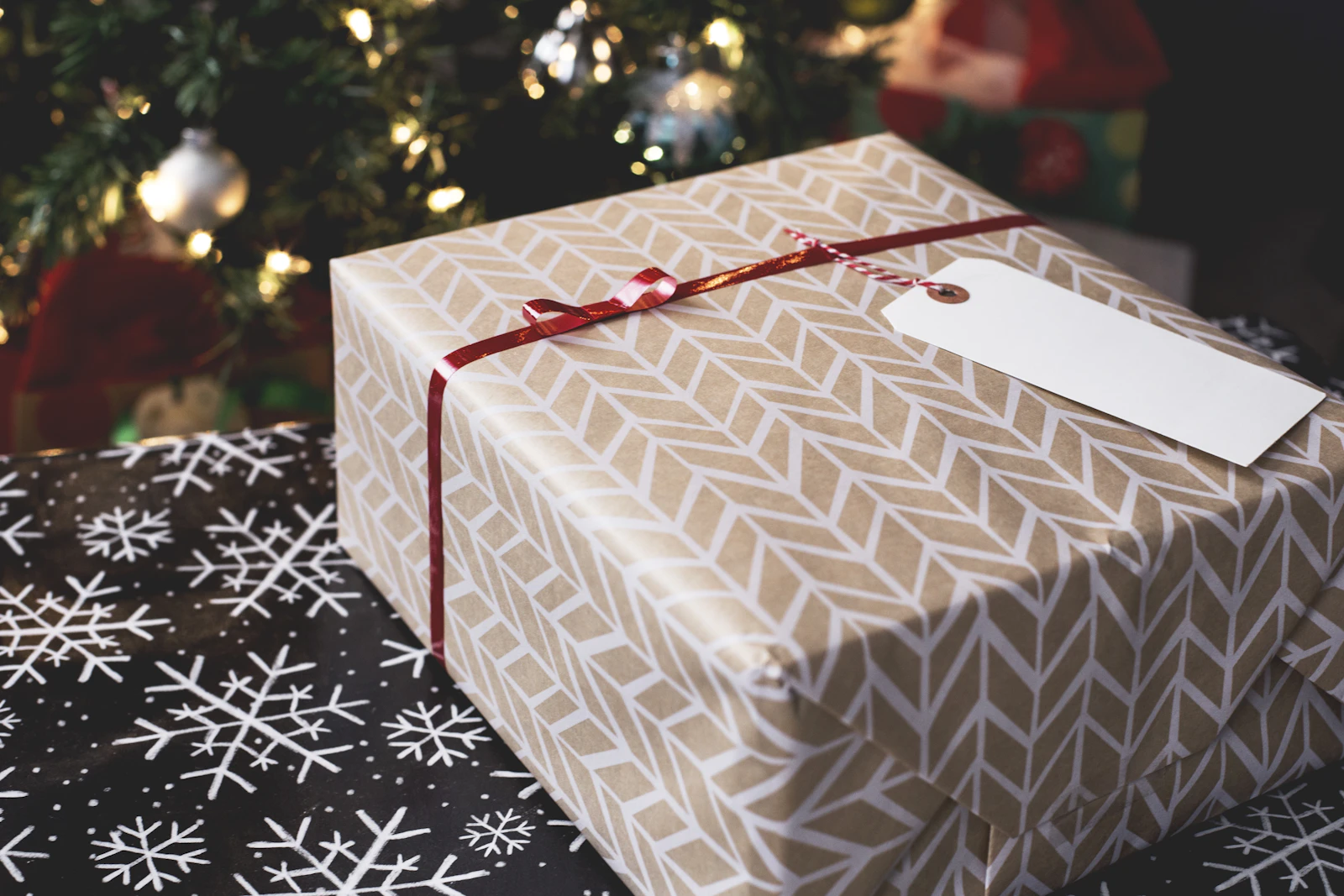 Gold and white Christmas gift box on a festive patterned surface