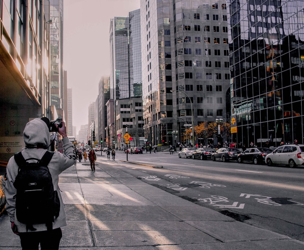 grayscale photography of person standing beside road during daytime