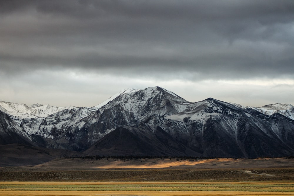 montanha coberta de neve sob céu nublado durante o dia