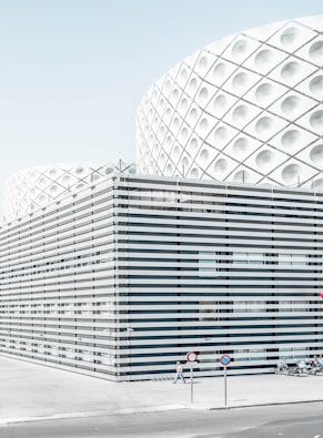 photo of man walking beside architectural building