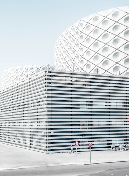 photo of man walking beside architectural building