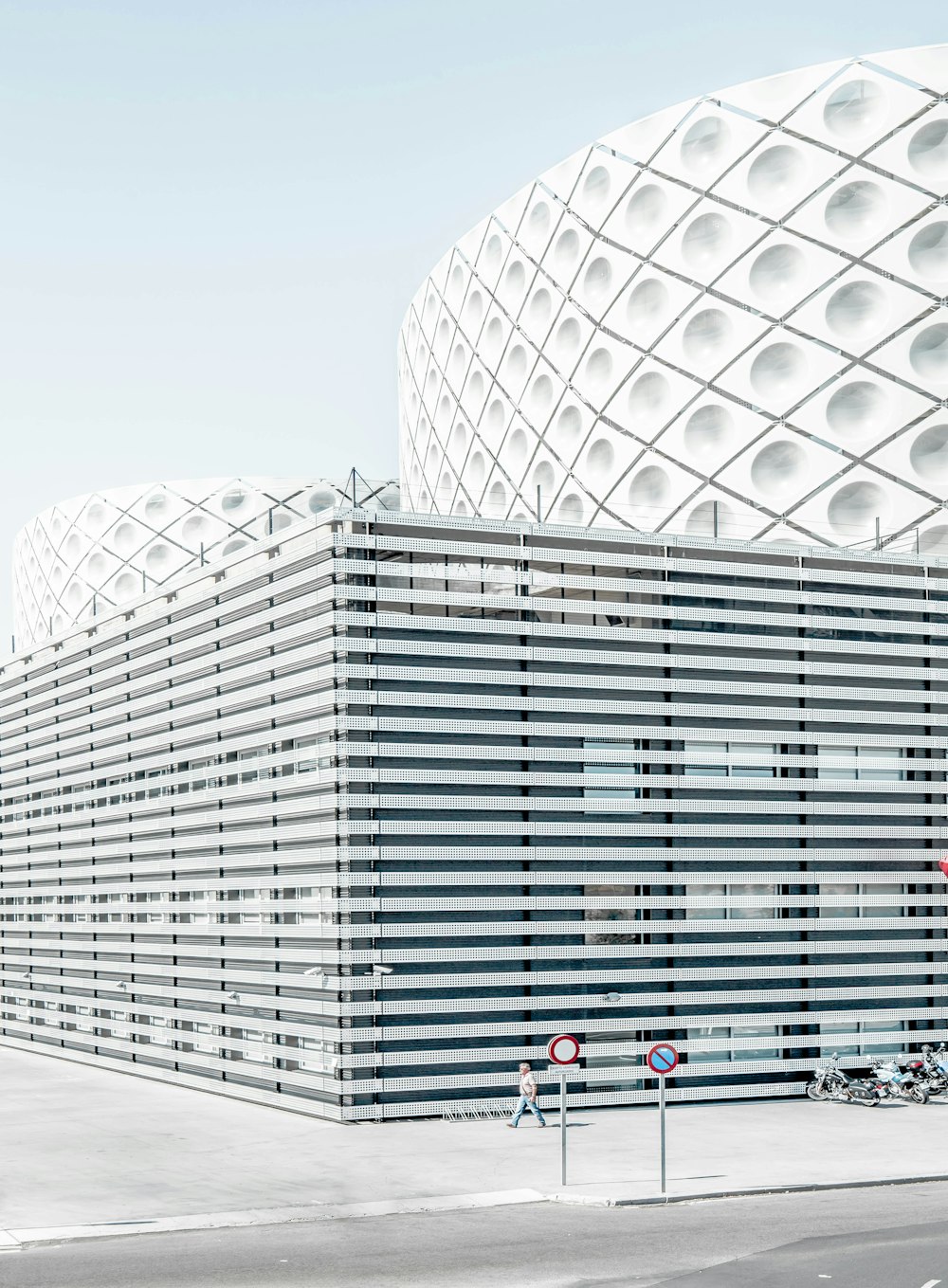 photo of man walking beside architectural building